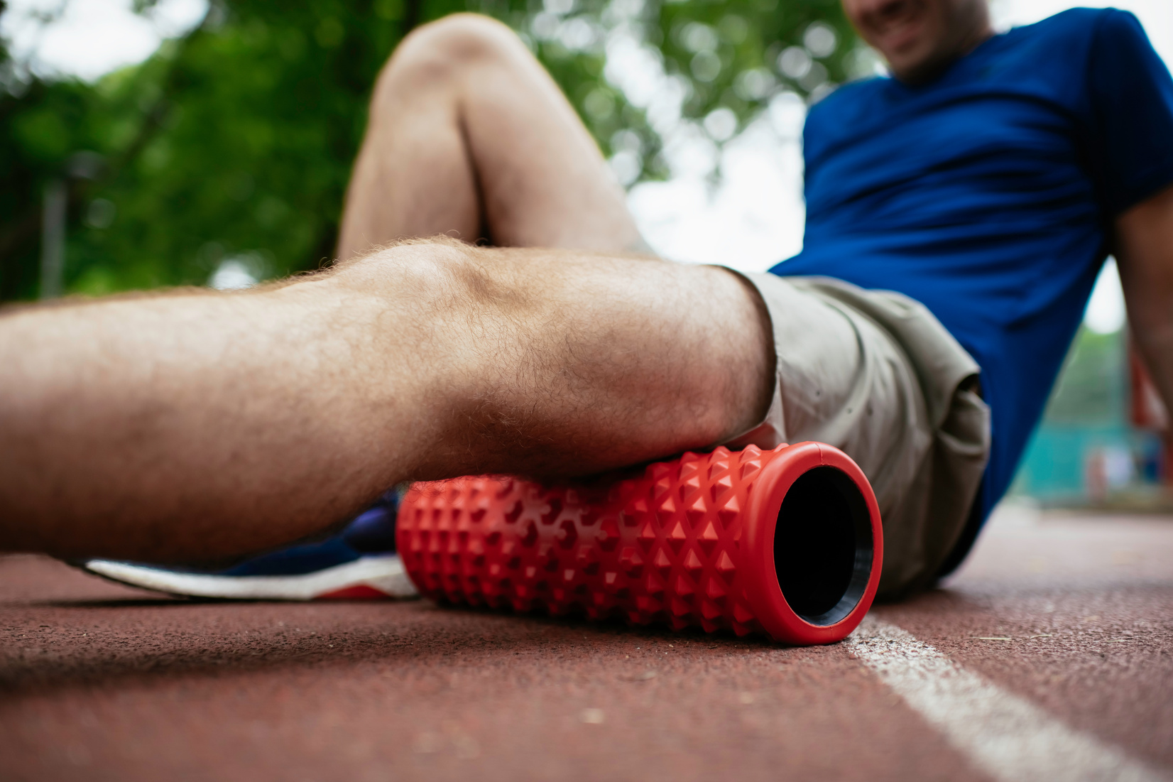 Athlete stretches using foam roller.